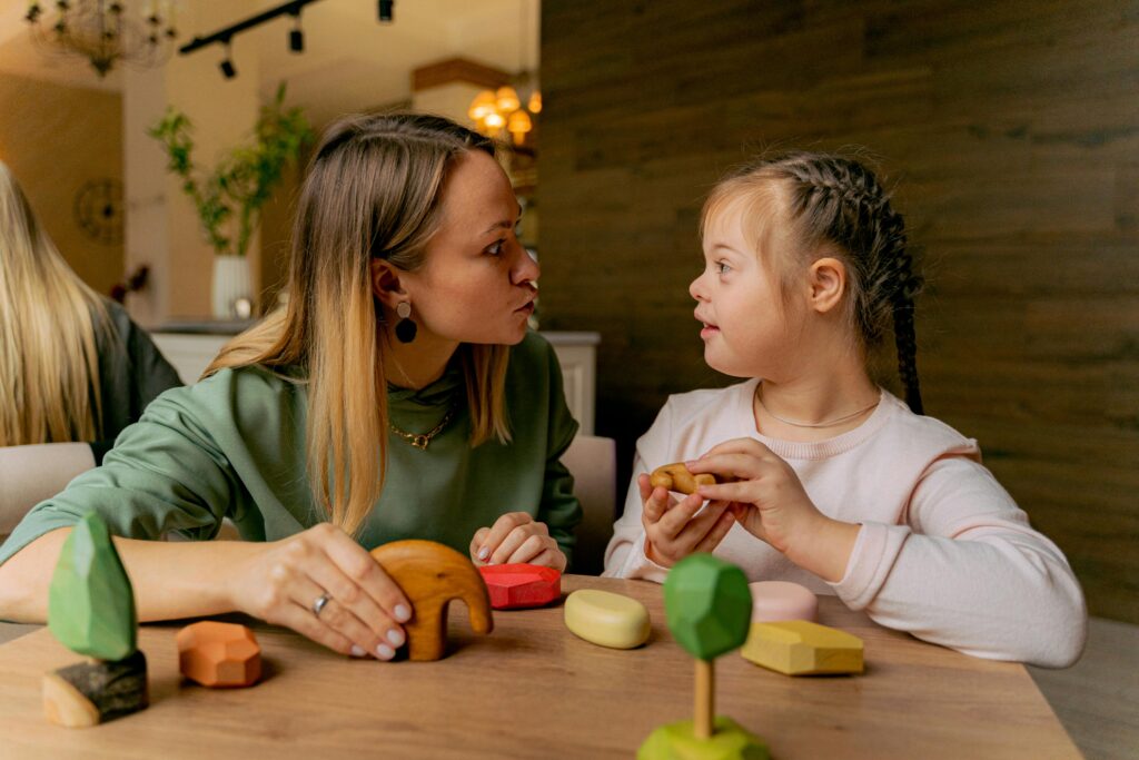 Little girl playing with wooden toys with therapist