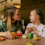 Little girl playing with wooden toys with therapist
