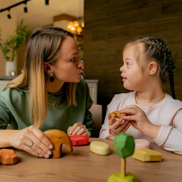 Little girl playing with wooden toys with therapist